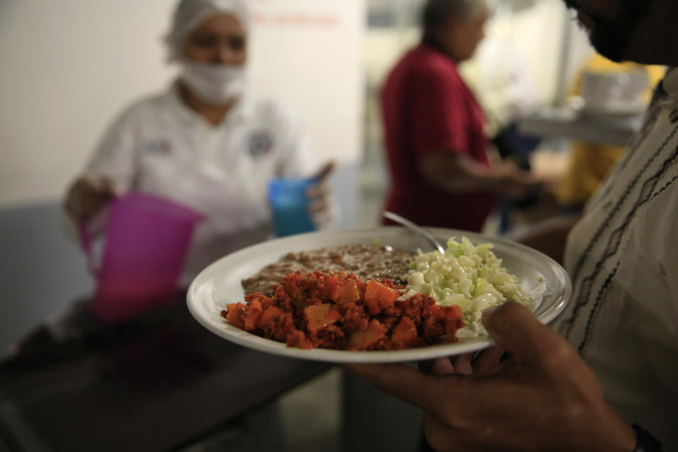 Workers serve dinner to journalists in the dining hall of the now closed Morelos detention center during a media tour of the former Islas Marias penal colony, located off Mexico's Pacific coast, late Friday, March 15, 2019. Officials say inmates brewed homemade liquor out of fermented fruit and some tried to grow marijuana. The moonshine, known on the island as "turbo," led to a ban on the possession of sugar by inmates, since it accelerated the fermentation process. (AP Photo/Rebecca Blackwell)