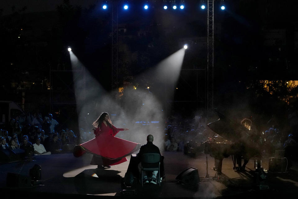 French Pianist Simon Ghraichy performs next to French-Iranian dancer Rana Gorgani during a concert in the ancient northeastern city of Baalbek, Lebanon, Sunday, July 17, 2022. Lebanon's renowned Baalbek Festival is back, held in front of a live audience for the first time in two years amid an ongoing economic meltdown. (AP Photo/Hassan Ammar)