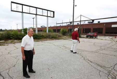 Gerald Poor (L) and long time friend and former co-worker Larry Terrell look at the now shuttered BorgWarner factory in Muncie, Indiana, U.S., August 13, 2016. Poor worked at the factory for over 40 years. REUTERS/Chris Bergin