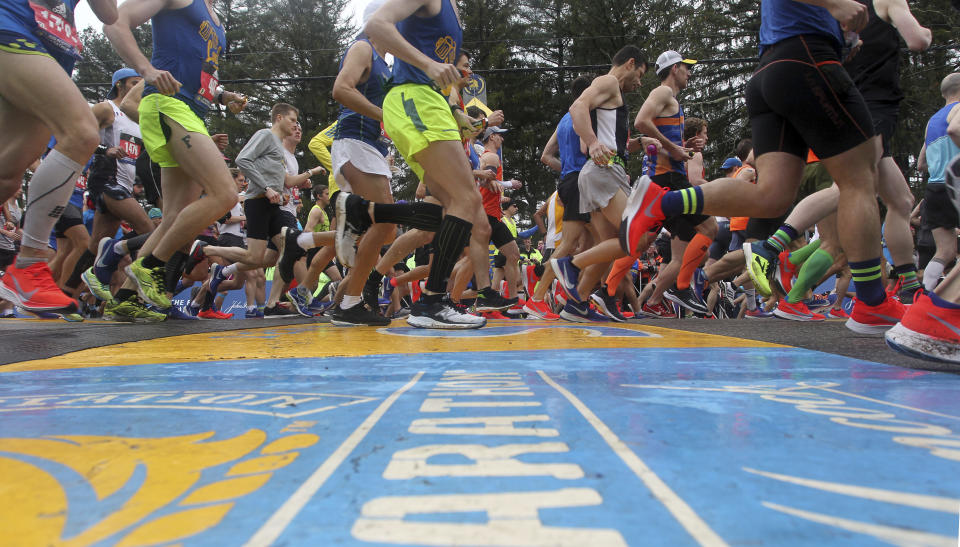 FILE - Runners cross the start line of the 123rd Boston Marathon on Monday, April 15, 2019, in Hopkinton, Mass. Once a year for the last 100 years, Hopkinton becomes the center of the running world, thanks to a quirk of geography and history that made it the starting line for the world's oldest and most prestigious annual marathon. (AP Photo/Stew Milne, File)