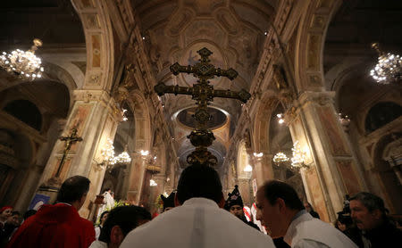 Members of the church hold a cross during a mass at the Santiago cathedral, in Santiago, Chile July 25, 2018. Picture taken July 25, 2018. REUTERS/Ivan Alvarado