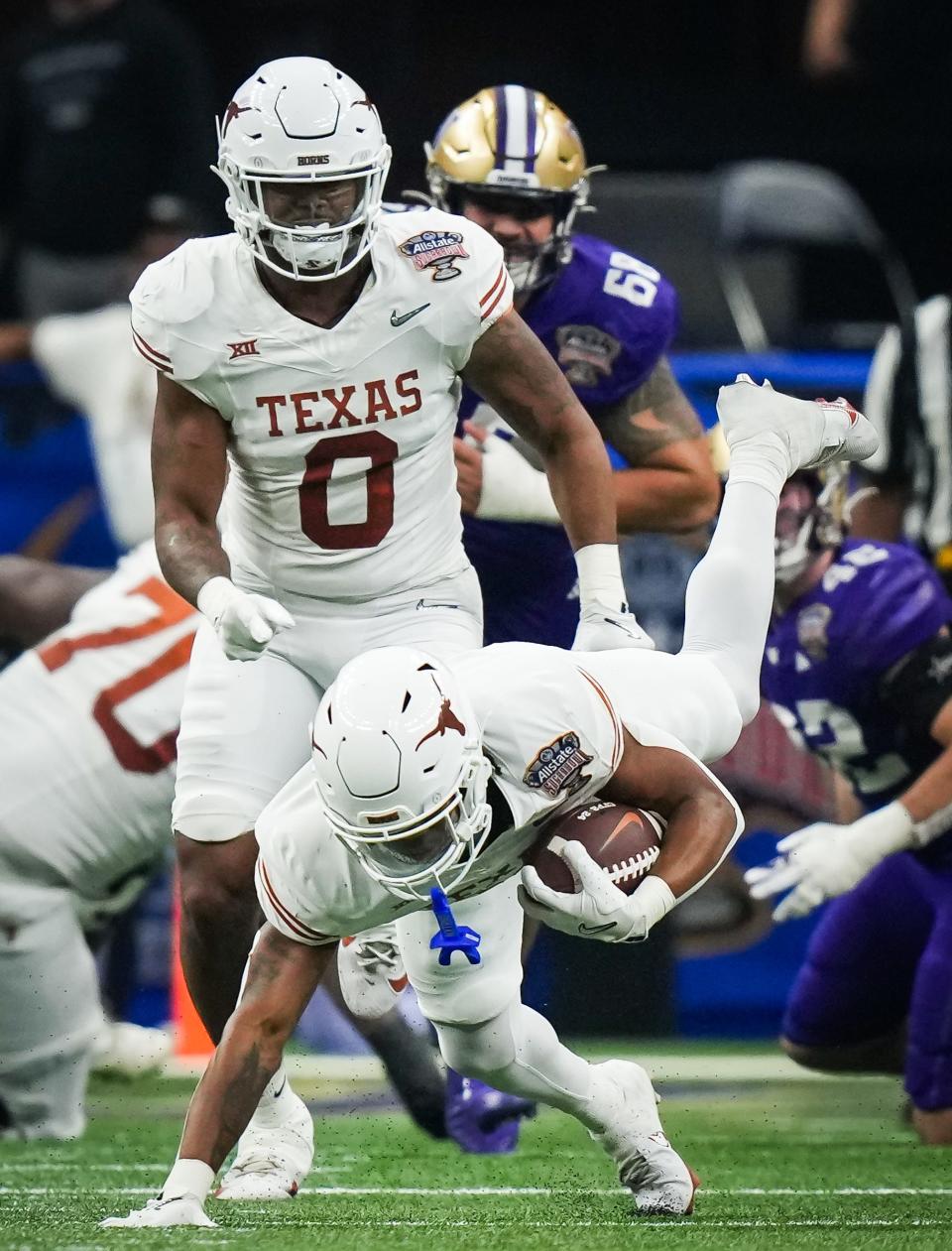 Texas running back Jaydon Blue is tackled during a 37-31 loss to Washington at the Sugar Bowl in New Orleans. Blue had one of two Longhorn fumbles as they finished the season at 12-2.