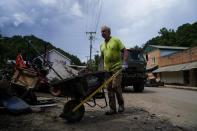 Jeff Hawkins helps clean his father's antique shop, called Curiosity Shop, on Friday, Aug. 5, 2022, in Fleming-Neon, Ky., after massive flooding. When the storm hit, Jeff Hawkins was about two weeks from opening a multipurpose center in a former car dealership. The longtime educator who’s lived here since he was a teenager has big plans for the project he’s dubbed Neon Lights _ a performing arts studio, an internet cafe, event space, and an innovation incubator. (AP Photo/Brynn Anderson)