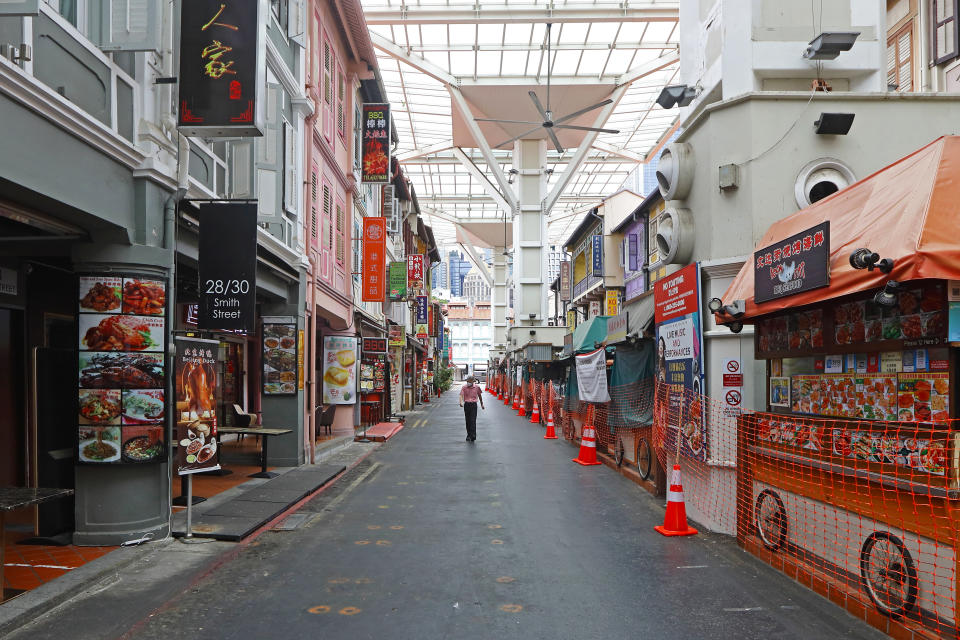 SINGAPORE - APRIL 07:  A man wearing protective mask walks along a closed shops in Chinatown on April 7, 2020 in Singapore. Singapore government starts closing non-essential workplaces and schools temporarily for a month from today, April 7 to contain the spread of the COVID-19 infections.  (Photo by Suhaimi Abdullah/Getty Images)