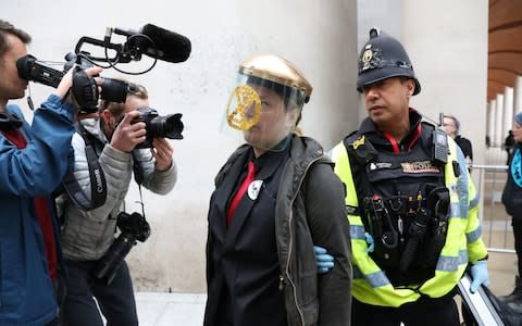 Police remove Extinction Rebellion protesters who have glued themselves to the entrances at the London Stock Exchange - Credit: Isabel Infantes/PA