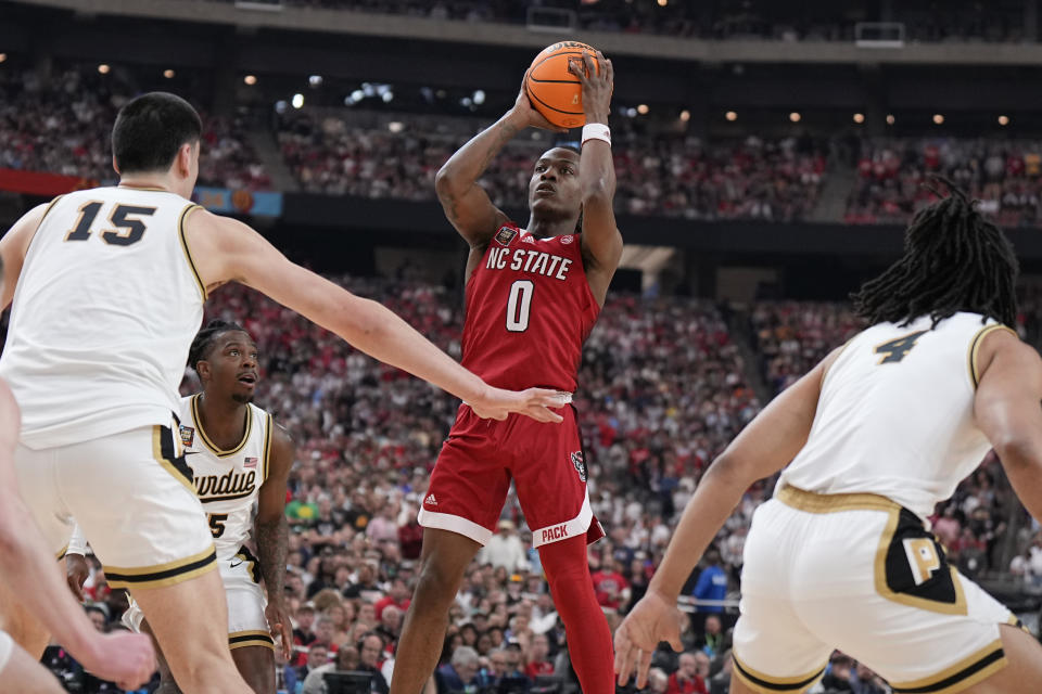 NC State guard DJ Horne (0) shoots as p15= defends during the first half of the NCAA college basketball game at the Final Four, Saturday, April 6, 2024, in Glendale, Ariz. (AP Photo/Brynn Anderson )