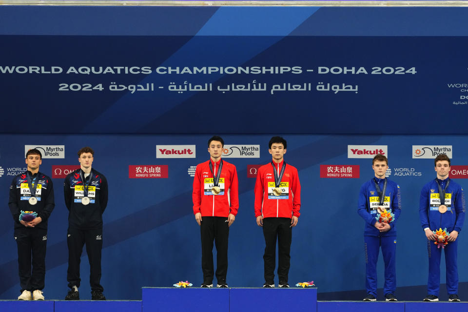 Lian Junjie and Yang Hao of China, center, Thomas Daley and Noah Williams of Great Britain, left, and Kirill Boliukh and Oleksii Sereda of Ukraine stand at the podium with their medals during the Men's synchronized 10m platform diving final at the World Aquatics Championships in Doha, Qatar, Thursday, Feb. 8, 2024. China won gold, Great Britain silver and Ukraine the bronze. (AP Photo/Hassan Ammar)