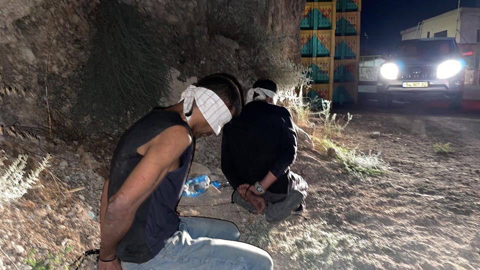 In this photo provided by Israel Police, Zakaria Zubeidi, left, and Mohammed Aradeh, two of the six Palestinian fugitives, are blindfolded and handcuffed after being recaptured in the Arab town of Umm al-Ghanam, northern Israel, Saturday, Sept. 11, 2021. Israeli police on Saturday said they have arrested four of the six Palestinians who broke out of a maximum-security prison this week including Zubeidi, a famed militant leader whose exploits over the years have made him a well-known figure in Israel. (Israeli Police via AP)