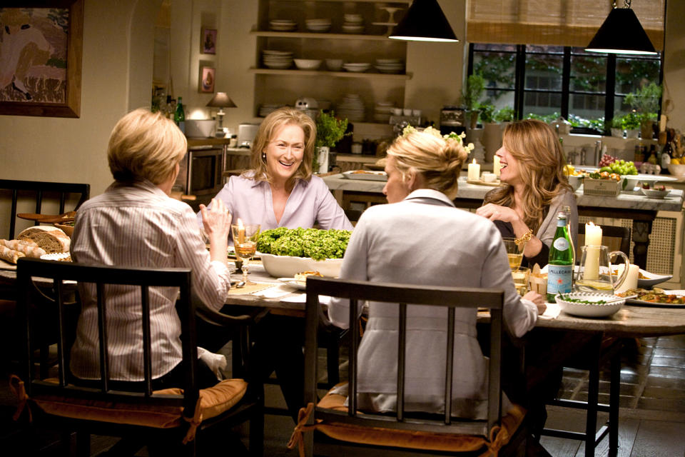 Meryl Streep, Amy Adams, and others share a meal and conversation around a dining table in a cozy kitchen setting