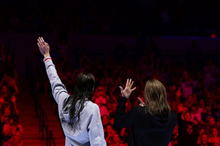 Kate Douglass waves to the crowd as Lilly King of the United States shows off her engagement ring during a ceremony after the Women's 200m breaststoke final at the US Olympic swimming trials (Sarah Stier)