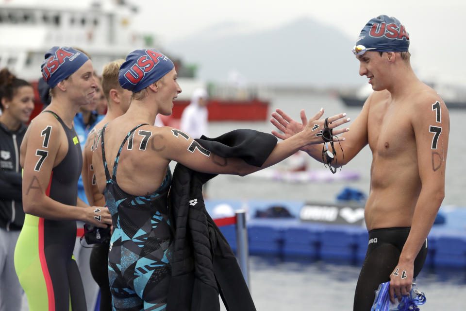 Members of the team from the United States react after winning a bronze medal in the 5km mixed relay open water swim at the World Swimming Championships in Yeosu, South Korea, Thursday, July 18, 2019. (AP Photo/Mark Schiefelbein)