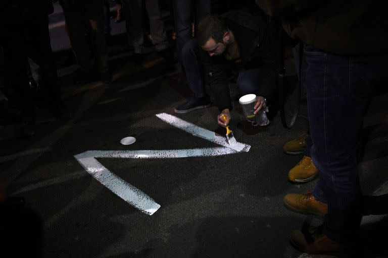 Un manifestante pinta el signo "Z" en una calle, en referencia a los tanques rusos marcados con la letra, durante una manifestación organizada por organizaciones de la derecha serbia en apoyo de la invasión rusa en Ucrania, en Belgrado el 4 de marzo de 2022.