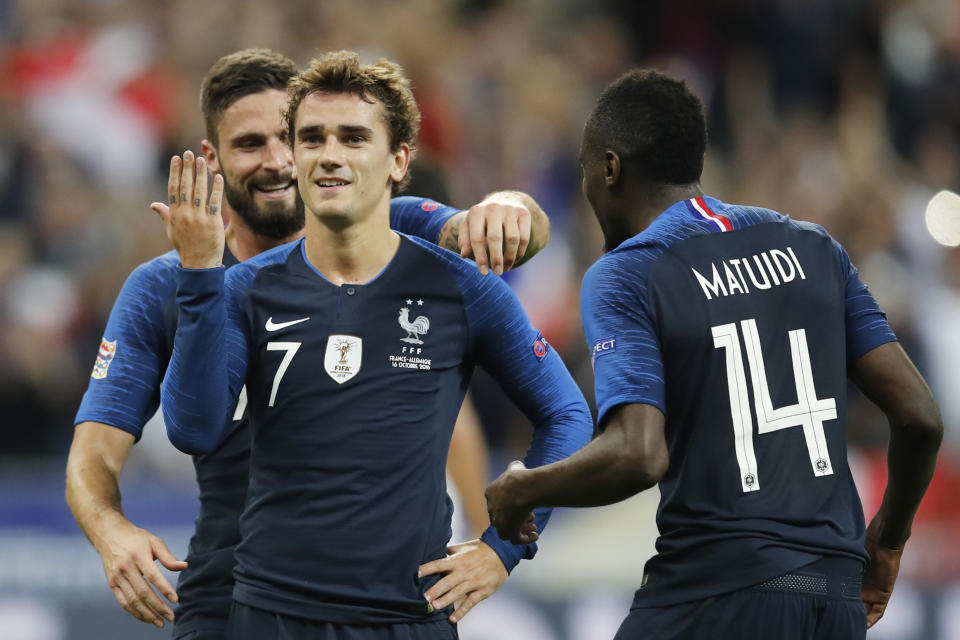 El delantero francés Antoine Griezman es felicitado por sus compañeros Olivier Giroud (izquierda) y Blaise Matuidi (derecha) tras marcar de penal el segundo gol en la victoria 2-1 ante Alemania en el partido por la Liga de las Nacione en el Stade de France en Saint Denis, al norte de París, el martes 16 de octubre de 2018. (AP Foto/Christophe Ena)