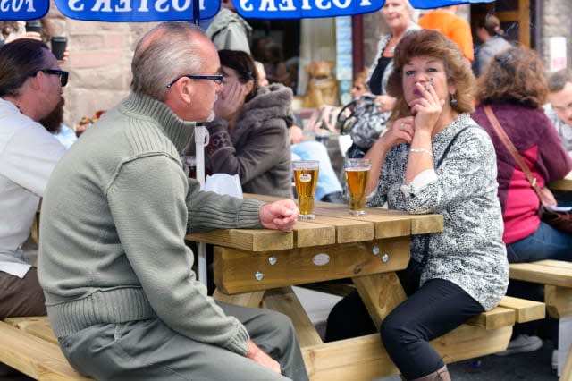 Woman smoking a cigarette in a pub beer garden, Abergavenny, Wales, UK.