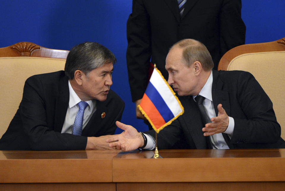 Kyrgyzstan President Almazbek Atambayev, left, chats with Russian President Vladimir Putin during a signing ceremony at the Shanghai Cooperation Organization (SCO) summit in the Great Hall of the People in Beijing, China Thursday, June 7, 2012. (AP Photo/Mark Ralston, Pool)