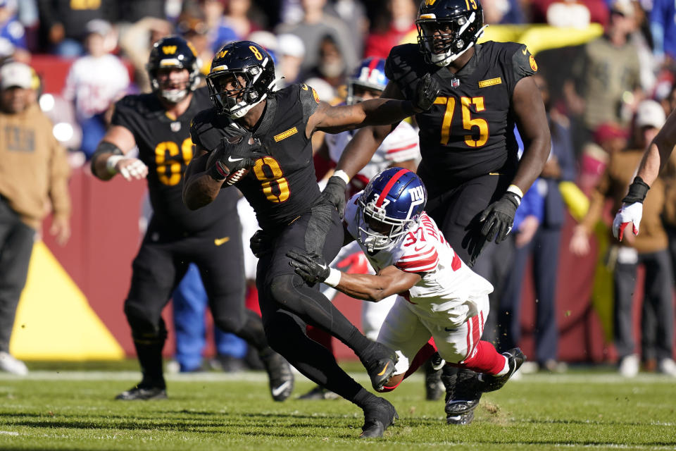 Washington Commanders running back Brian Robinson Jr. (8) breaking away from New York Giants cornerback Tre Hawkins III (37) during the first half of an NFL football game, Sunday, Nov. 19, 2023, in Landover, Md. (AP Photo/Stephanie Scarbrough)