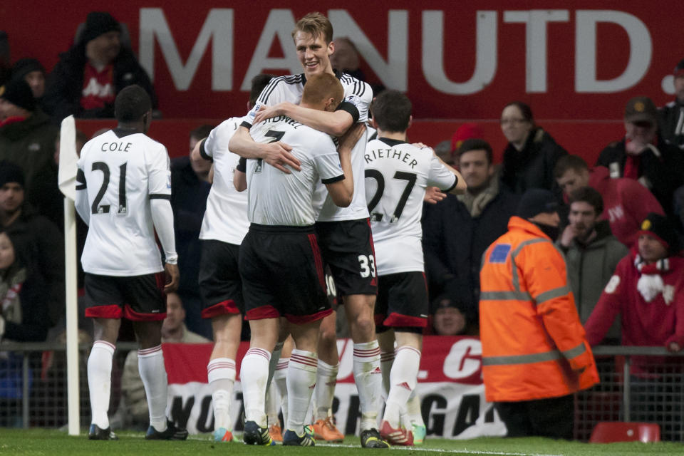 Fulham players celebrate after they drew 2-2 with a late goal from Darren Bent during their English Premier League soccer match against Manchester United at Old Trafford Stadium, Manchester, England, Sunday Feb. 9, 2014. (AP Photo/Jon Super)