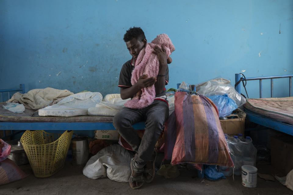 Tigrayan 19-year-old refugee Goytom Tsegay, tries to comfort his 4-month-old niece, Turfu Gebremariam, inside their family's shelter in Hamdayet, eastern Sudan, near the border with Ethiopia, on March 21, 2021. “I spend the whole day with them. ... My favorite part is feeding them. I’ve decided to stay with them all their lives.” (AP Photo/Nariman El-Mofty)