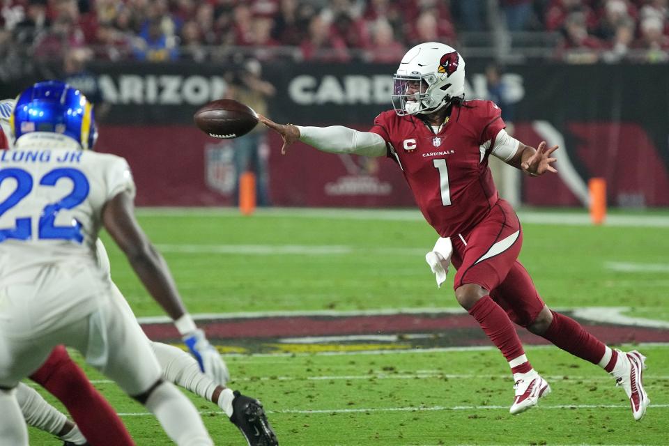 Arizona Cardinals quarterback Kyler Murray (1) tosses the ball to a teammate as Los Angeles Rams defensive back David Long (22) looks on during the first half of an NFL football game Monday, Dec. 13, 2021, in Glendale, Ariz. (AP Photo/Rick Scuteri)