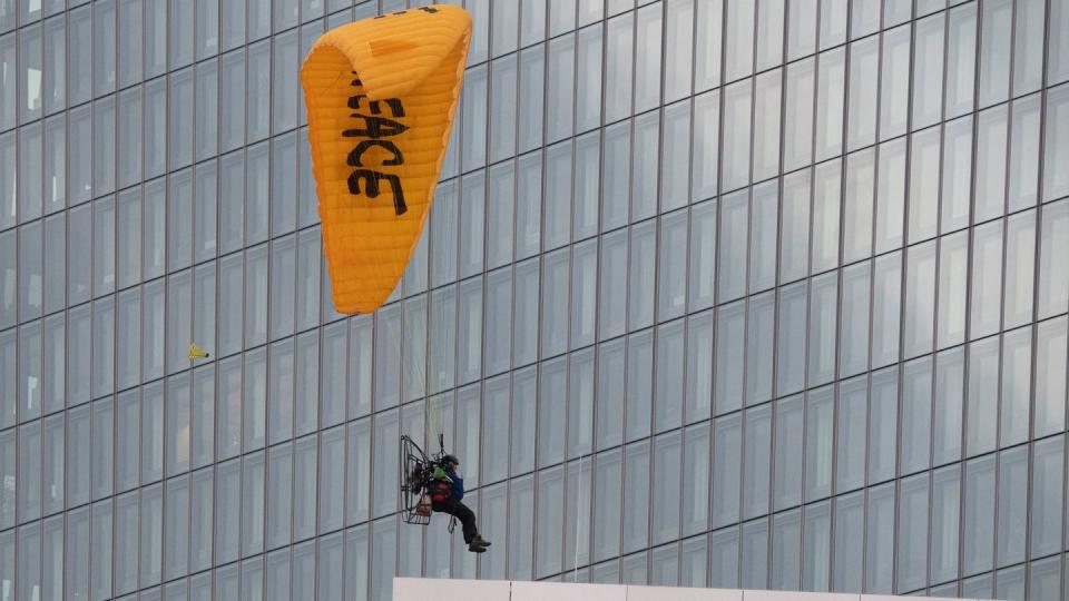 Mit einem Gleitschirm landet ein Greenpeace-Aktivist auf dem Dach der Europäischen Zentralbank (EZB).