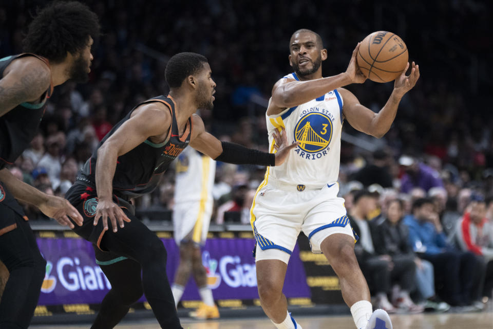 Golden State Warriors guard Chris Paul (3) passes the ball while Washington Wizards guard Jared Butler, center, and forward Marvin Bagley III, left, defend during the first half of an NBA basketball game in Washington, Tuesday, Feb. 27, 2024. (AP Photo/Manuel Balce Ceneta)