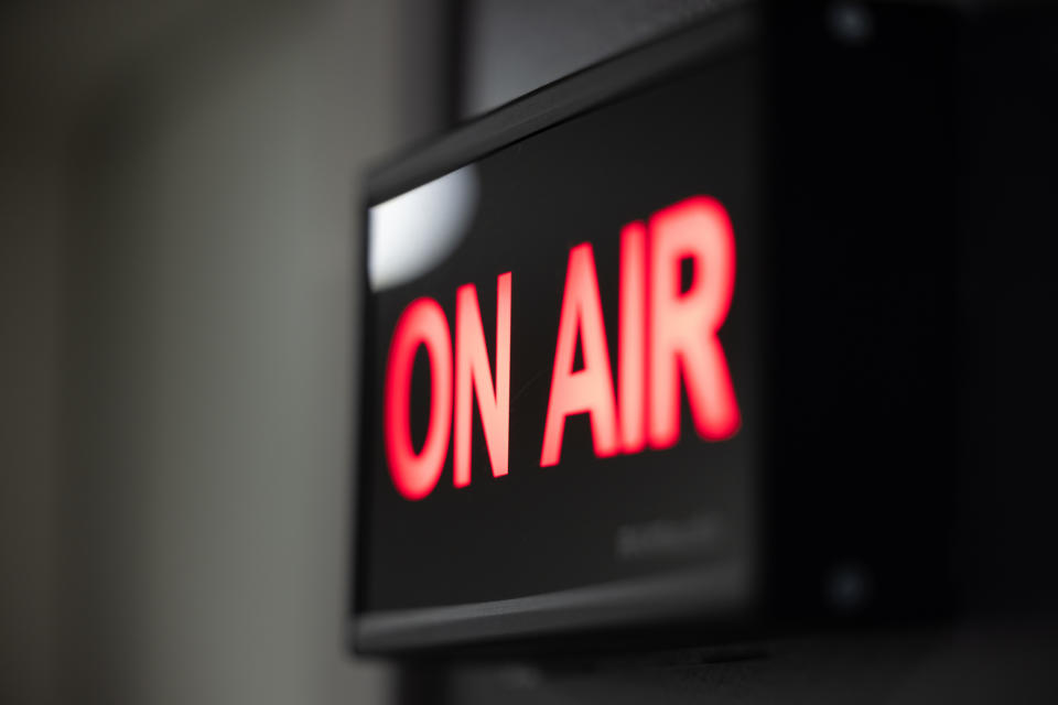 A sign that reads "ON AIR" in bright red letters, indicating that a broadcast is currently live