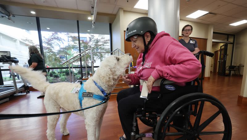 Joyce Collingwood leans in close to Cooper, a therapy dog, at St. Marks Hospital in Salt Lake City on Monday, June 12, 2023. The canine therapy program is resuming following COVID-19.