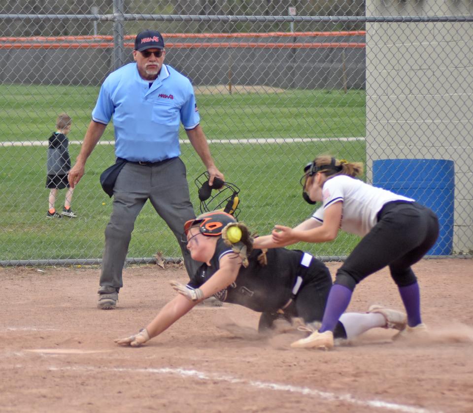 Quincy's Payton Gross scores on a play at the plate after the ball is jarred loose from the pitcher's glove versus Concord