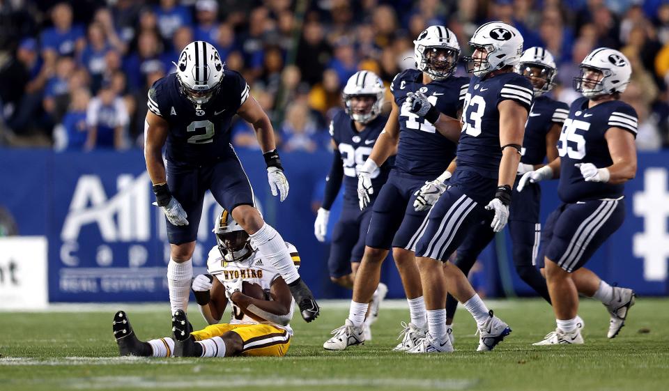 BYU linebacker Ben Bywater steps over Wyoming running back Dawaiian McNeely after a play at LaVell Edwards Stadium.