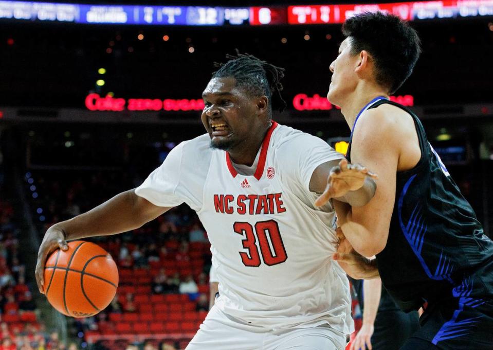 N.C. State’s DJ Burns Jr. posts up against Saint Louis’ Bruce Zhang during the first half of the Wolfpack’s game on Wednesday, Dec. 20, 2023, at PNC Arena in Raleigh, N.C.