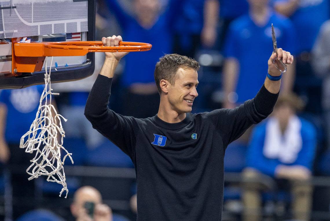 Duke coach Jon Scheyer celebrates by cutting down the net after leading the Blue Devils to an ACC Tournament Championship with a 59-49 victory over Virginia on Saturday, March 11, 2023 at the Greensboro Coliseum in Greensboro, N.C.