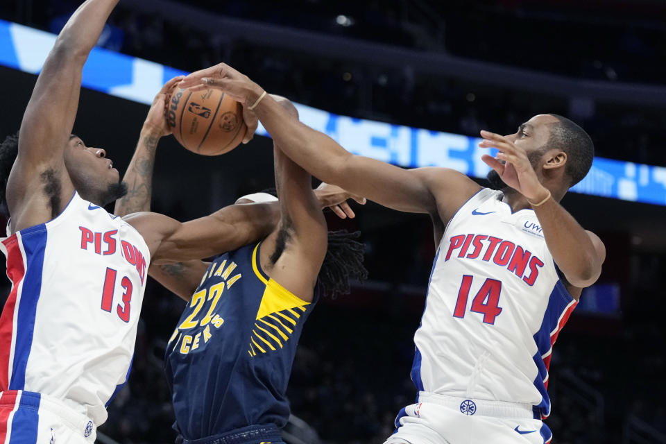 Indiana Pacers forward Isaiah Jackson (22) is foulded by Detroit Pistons center James Wiseman (13) as guard Alec Burks (14) reaches in during the first half of an NBA basketball game, Monday, Dec. 11, 2023, in Detroit. (AP Photo/Carlos Osorio)