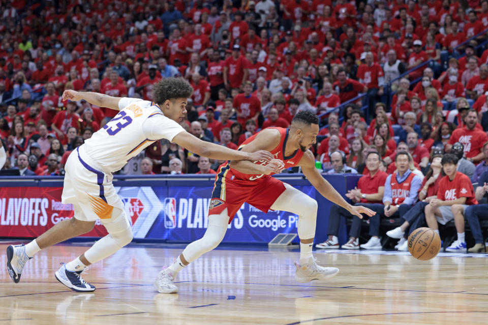 New Orleans Pelicans guard CJ McCollum (3) steals the ball from Phoenix Suns forward Cameron Johnson (23) in the first half of Game 3 of an NBA basketball first-round playoff series in New Orleans, Friday, April 22, 2022. (AP Photo/Michael DeMocker)