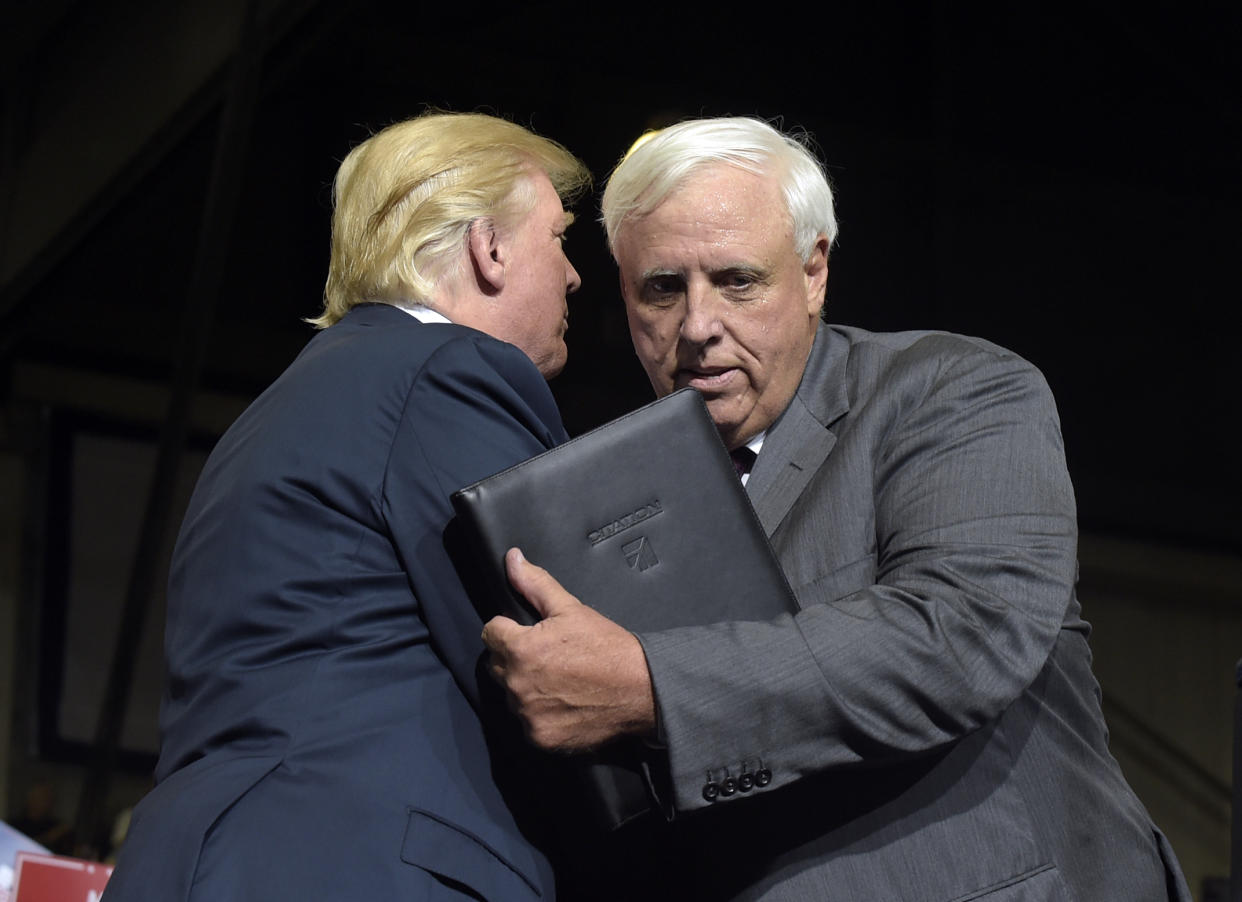 President Donald Trump embraces West Virginia Gov. Jim Justice after Justice announced during a rally that he was switching his registration to Republican: AP/Susan Walsh