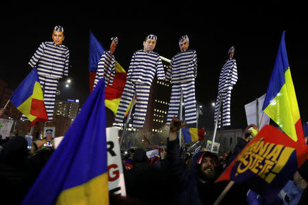 FILE PHOTO: Protesters hold effigies with the faces of leader of Romania's leftist Social Democrat Party (PSD) Liviu Dragnea (R) and other members of the party dressed as prisoners, during a demonstration in Bucharest, Romania, February 3, 2017. REUTERS/Stoyan Nenov/File Photo