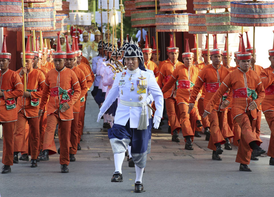 The royal guard march as Thailand's King Maha Vajiralongkorn is transported on the royal palanquin by royal bearers during the Royal Procession on Land to encircle the city for the king's coronation ceremonis Sunday, May 5, 2019, in Bangkok, Thailand. (AP Photo/Sakchai Lalit)