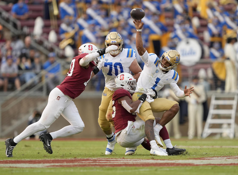 UCLA quarterback Dorian Thompson-Robinson (1) is pressured by Stanford linebacker Ricky Miezan, center, and linebacker Jordan Fox, left, during the second half of an NCAA college football game Saturday, Sept. 25, 2021, in Stanford, Calif. (AP Photo/Tony Avelar)