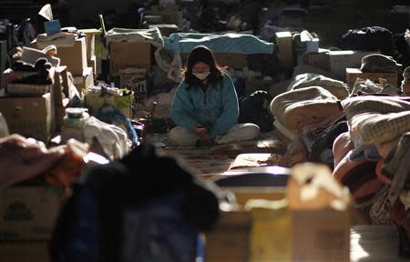 A woman looks at a mobile phone at a school, which now acts as a shelter for victims of the March 11 earthquake and tsunami, in Rikuzentakata, Iwate prefecture, in this April 7, 2011 file photo. REUTERS/Toru Hanai/Files