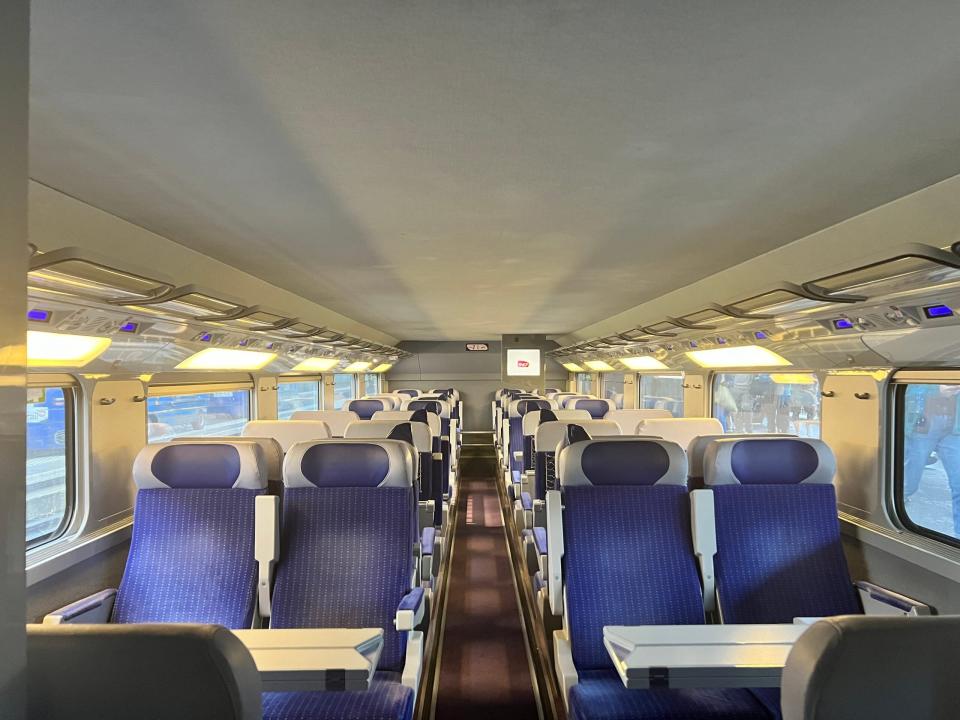 A second-class carriage on a TGV Lyria with blue cushioned seats