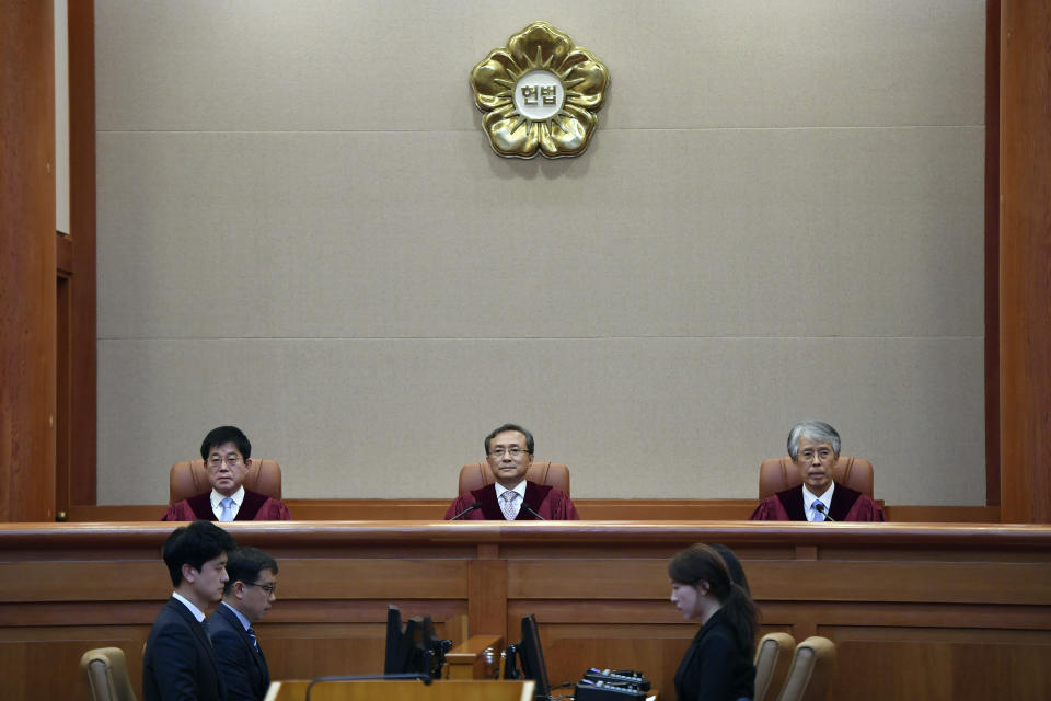 South Korea's Constitutional Court chief judge Yoo Nam-seok, center, and other judges sit for the ruling on decriminalization of abortion at the court in Seoul Thursday, April 11, 2019. South Korea's Constitutional Court has ruled that a decades-long ban on abortions is incompatible with the constitution, setting up a likely easing of restrictions. (Jung Yeon-je /Pool Photo via AP)