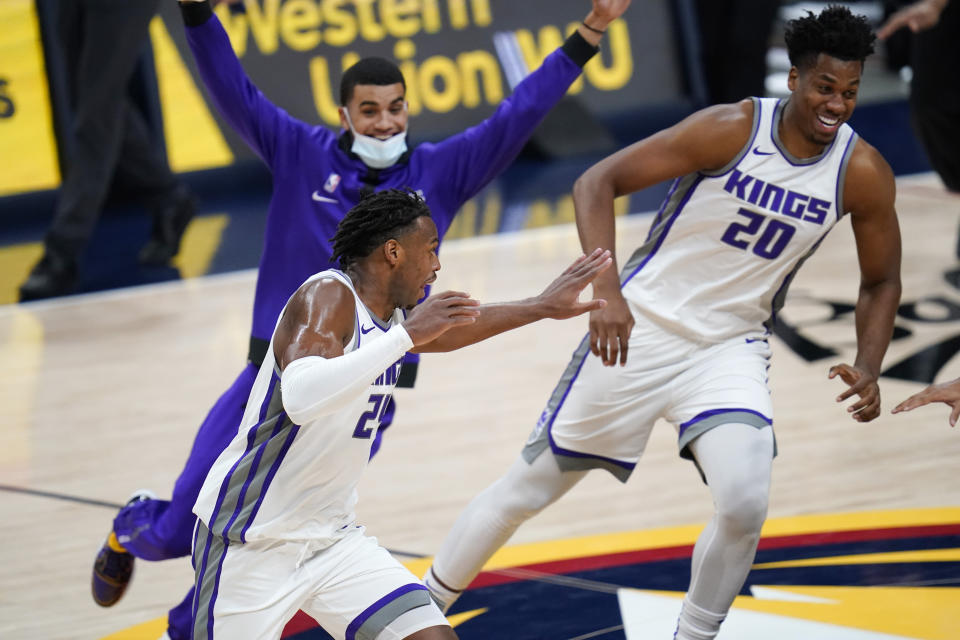 Sacramento Kings guard Buddy Hield, front left, runs off the court as teammates pursue him after he scored the winning basket in overtime of the team's NBA basketball game against the Denver Nuggets on Wednesday, Dec. 23, 2020, in Denver. (AP Photo/David Zalubowski)