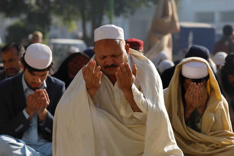 Men hold their palms as they attend the special prayers during a solar eclipse in Peshawar