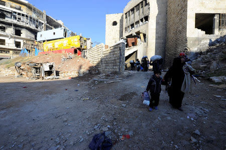 People, who evacuated the eastern districts of Aleppo, carry their belongings as they walk in a government held area of Aleppo, Syria December 9, 2016. REUTERS/Omar Sanadiki