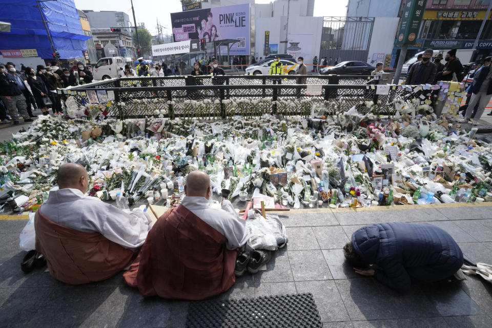 Buddhist monks pray for victims of a deadly accident following Saturday night's Halloween festivities on a street near the scene in Seoul, South Korea, Tuesday, Nov. 1, 2022. (AP Photo/Ahn Young-joon)