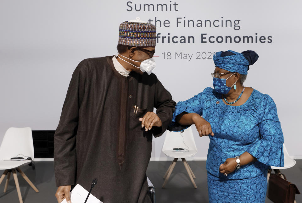 Nigeria's President Muhammadu Buhari, left, salutes the Director-General of the World Trade Organization Ngozi Okonjo-Iweala before the opening session at the Summit on the Financing of African Economies Tuesday, May 18, 2021 in Paris. More than twenty heads of state and government from Africa are holding talks in Paris with heads of international organizations on how to revive the economy of the continent, deeply impacted by the consequences of the COVID-19 pandemic. (Photo by Ludovic Marin, Pool via AP)