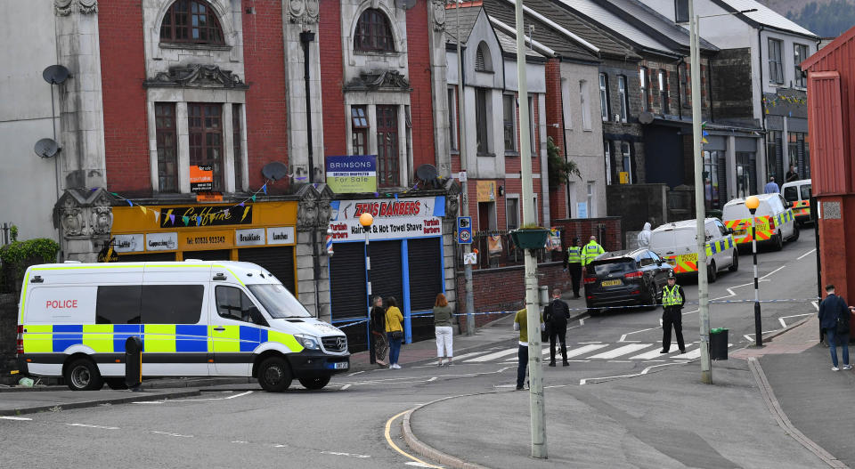 Police at the scene of a reported stabbing in the village of Pen Y Graig in South Wales.