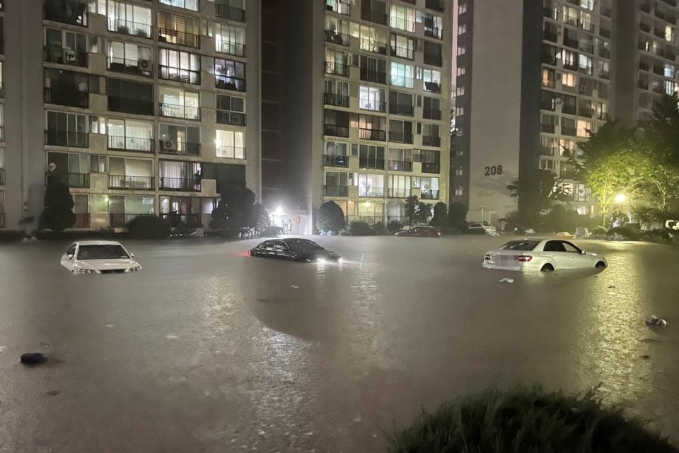 Vehicles partly submerged at a flooded parking lot in Seoul (REUTERS)