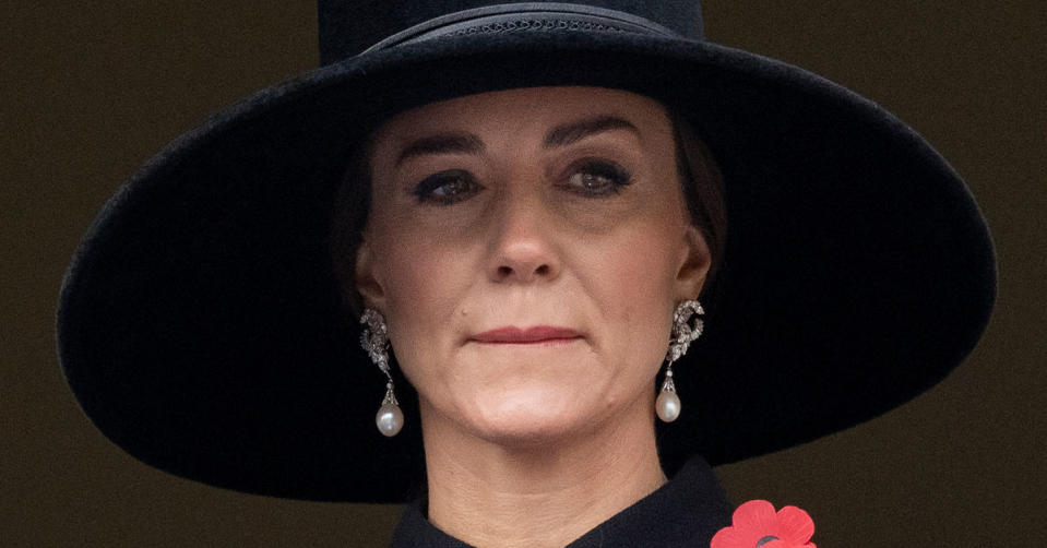 Kate Middleton wearing a large black hat and pearl earrings