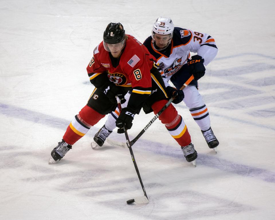 Stockton Heat's Juuso Valimaki, left, fights for the puck with Bakersfield Condors' Seth Griffith during the first round of the Calder Cup playoffs at the Stockton Arena in downtown Stockton on May 10.