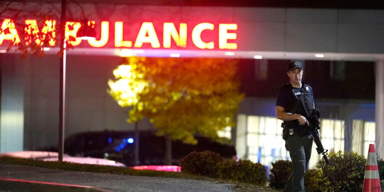 A law enforcement officer carries a rifle outside Central Maine Medical Center during an active shooter situation, in Lewiston, Maine